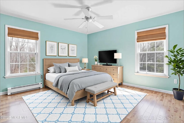 657 Toms River Rd, Jackson, NJ 08527 - bedroom featuring a baseboard radiator, baseboards, multiple windows, and wood finished floors