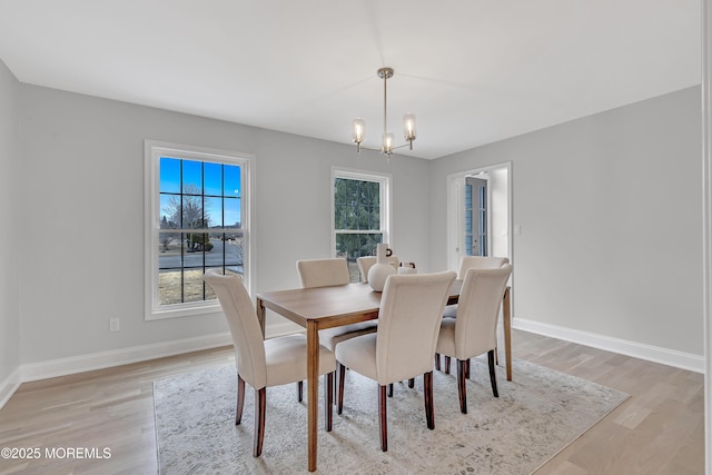 dining room with a notable chandelier and light wood-type flooring