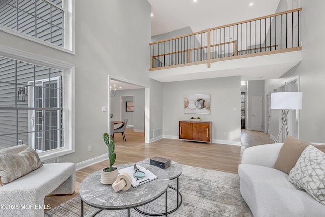 living room featuring a high ceiling and light wood-type flooring