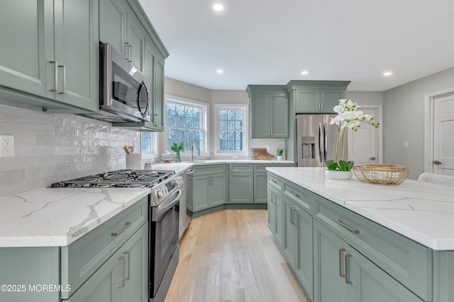 kitchen with stainless steel appliances and green cabinetry