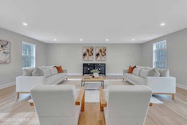 living room with plenty of natural light and light hardwood / wood-style flooring