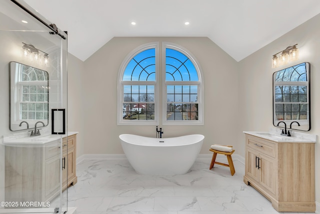 bathroom with lofted ceiling, a bath, and vanity