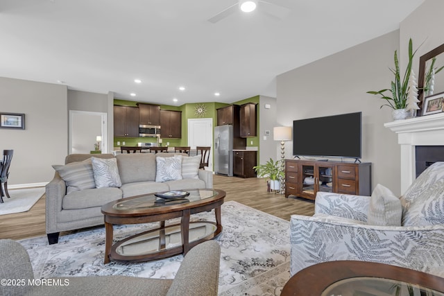 living room featuring ceiling fan and light hardwood / wood-style floors