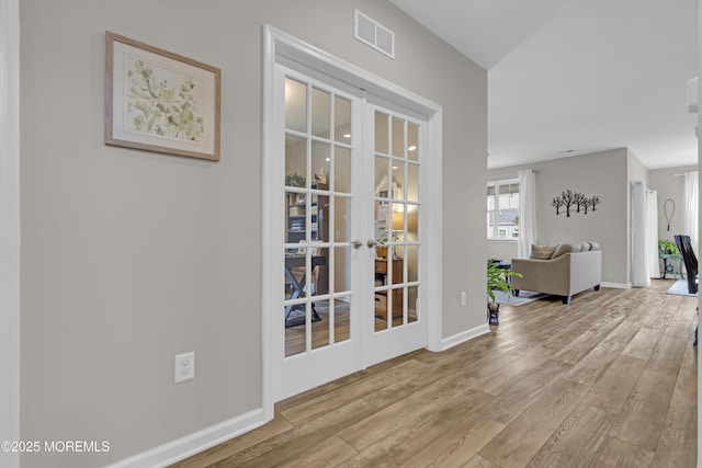 corridor featuring light hardwood / wood-style floors and french doors