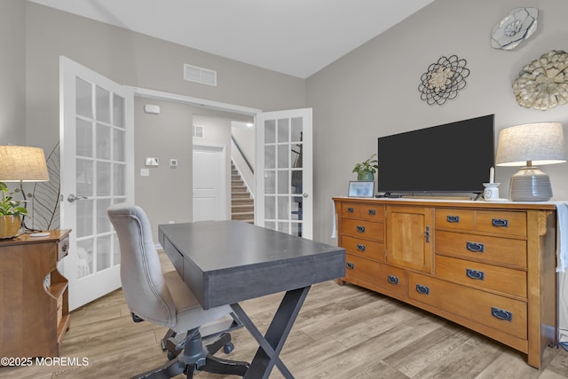 office space with light hardwood / wood-style floors and french doors