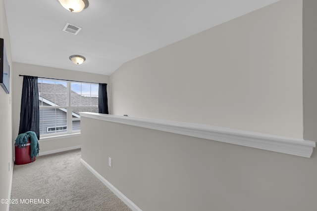 hallway featuring vaulted ceiling and carpet flooring