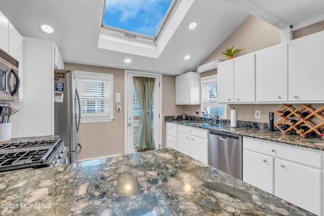 kitchen featuring dark stone countertops, sink, white cabinets, and appliances with stainless steel finishes