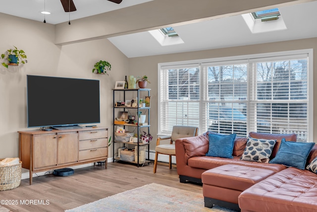 living room with ceiling fan, lofted ceiling with skylight, light hardwood / wood-style floors, and a baseboard radiator