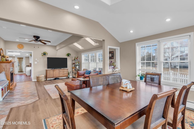 dining area featuring ceiling fan, light hardwood / wood-style floors, and vaulted ceiling