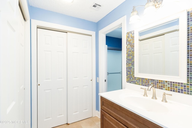 bathroom featuring tile patterned flooring, vanity, and a textured ceiling