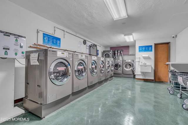 washroom with sink, washer and dryer, and a textured ceiling