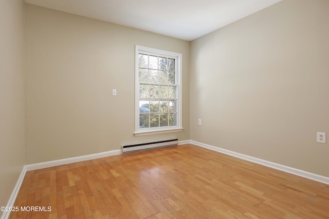 spare room with light hardwood / wood-style floors and a baseboard heating unit