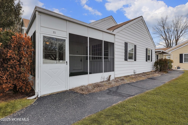 view of front of house featuring a sunroom and a front yard