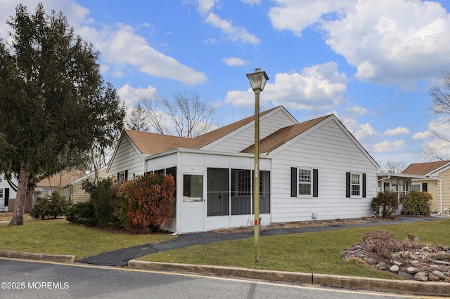 view of front facade with a sunroom and a front yard