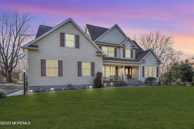 view of front of house featuring covered porch and a yard