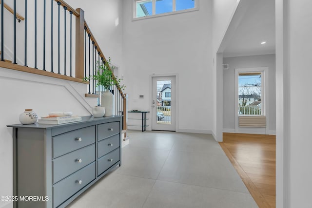 foyer entrance featuring a towering ceiling and plenty of natural light