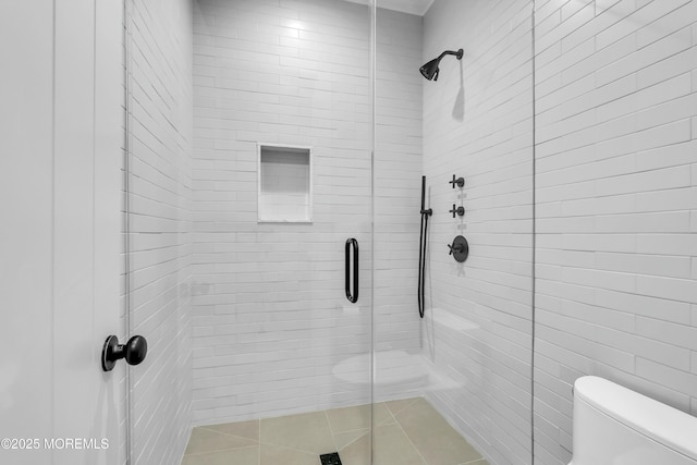 bathroom with a shower with shower door and toilet