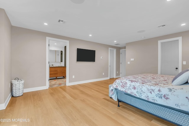 bedroom featuring light wood-type flooring and ensuite bath