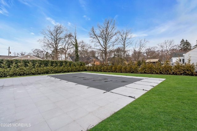 view of swimming pool featuring a patio and a yard