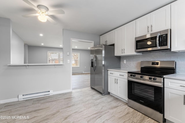 kitchen with a baseboard radiator, appliances with stainless steel finishes, decorative backsplash, and white cabinets