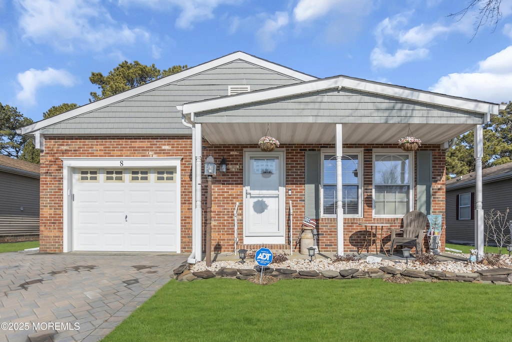 view of front of property with a garage, a front yard, and covered porch