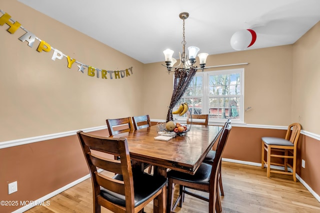 dining area featuring light hardwood / wood-style flooring and a chandelier