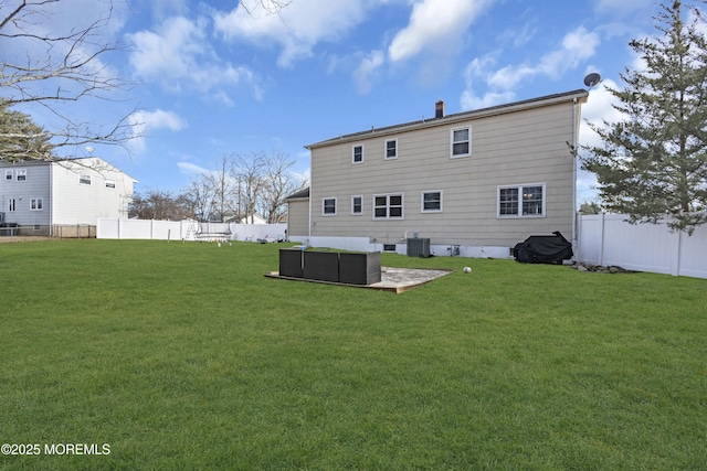 rear view of house with a patio area, central AC, and a lawn