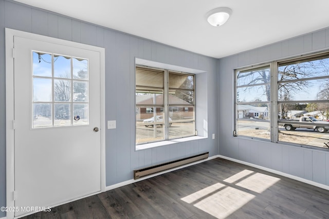 doorway featuring dark wood-style floors, a baseboard radiator, and baseboards