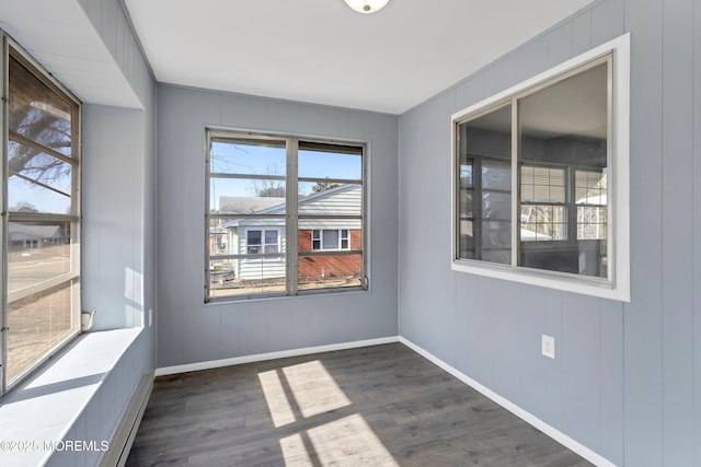 spare room with dark wood finished floors and baseboards