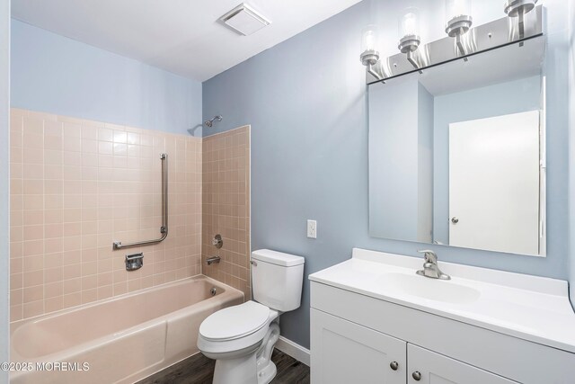 full bathroom with bathing tub / shower combination, visible vents, toilet, vanity, and wood finished floors