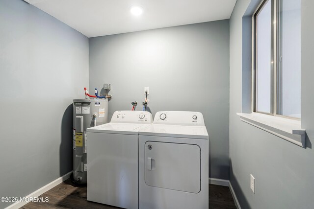 laundry area with dark wood finished floors, electric water heater, washer and dryer, laundry area, and baseboards