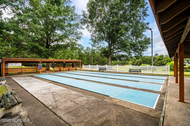 view of community featuring shuffleboard and fence