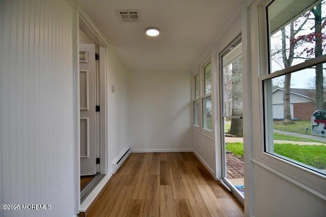 unfurnished sunroom with a baseboard heating unit