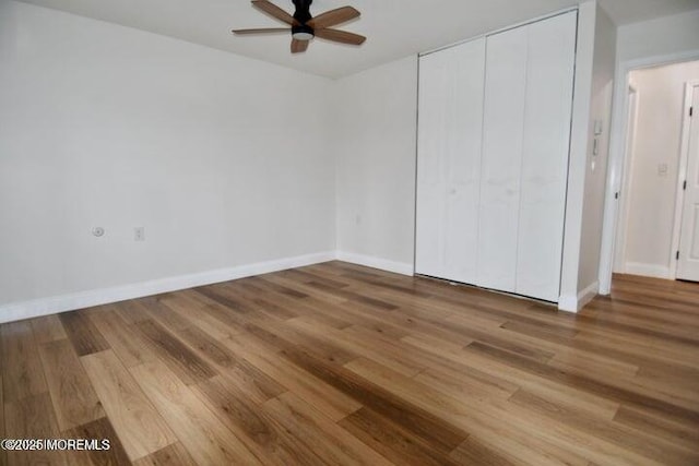 unfurnished bedroom featuring ceiling fan, wood-type flooring, and a closet