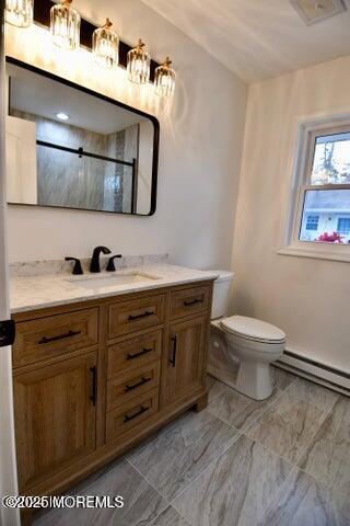 bathroom featuring vanity, a shower, a baseboard heating unit, and toilet