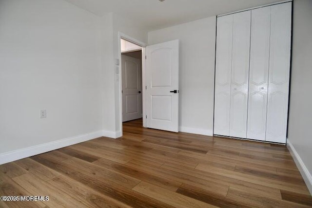 unfurnished bedroom with hardwood / wood-style flooring and a closet