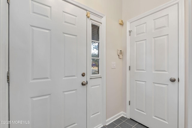 doorway with dark tile patterned floors