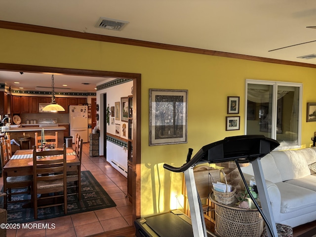 dining room featuring crown molding and dark tile patterned flooring