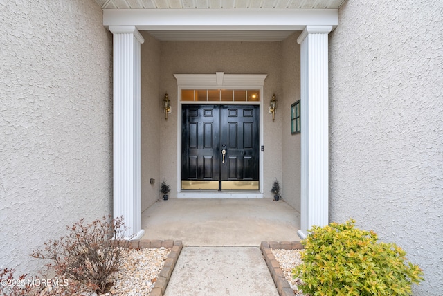 view of exterior entry featuring stucco siding