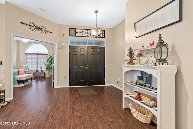 entrance foyer with a notable chandelier, wood finished floors, and baseboards