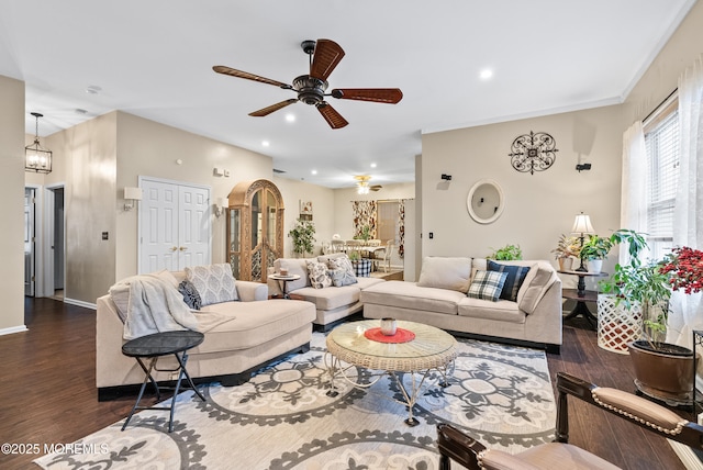 living room featuring ceiling fan with notable chandelier, recessed lighting, wood finished floors, and baseboards