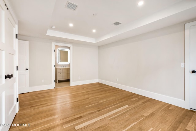 unfurnished bedroom with light wood-style flooring, visible vents, a raised ceiling, and recessed lighting