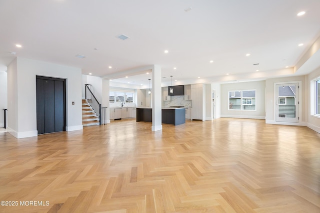 unfurnished living room featuring baseboards, recessed lighting, stairs, and elevator