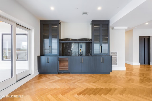 bar featuring visible vents, elevator, wine cooler, indoor wet bar, and recessed lighting