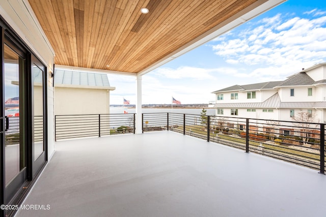 view of patio featuring a water view and a balcony