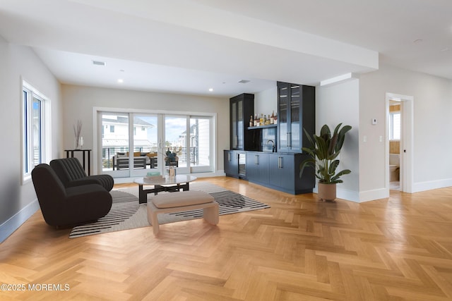 living room with visible vents, wet bar, baseboards, and recessed lighting