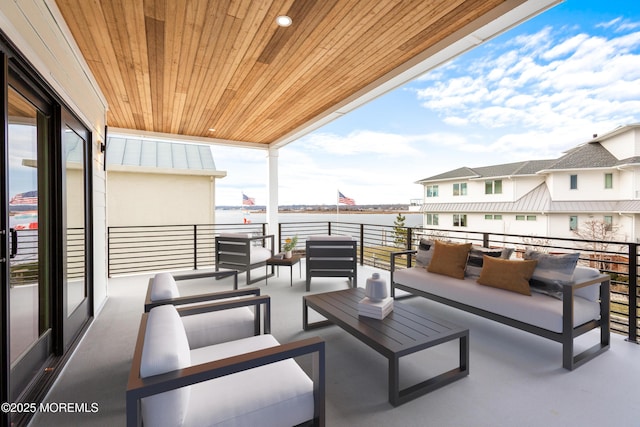 view of patio / terrace with a water view, a balcony, and an outdoor living space