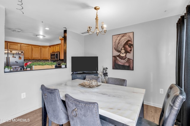 dining room featuring an inviting chandelier and dark wood-type flooring