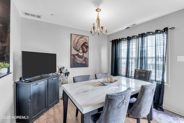 dining room featuring an inviting chandelier and light wood-type flooring