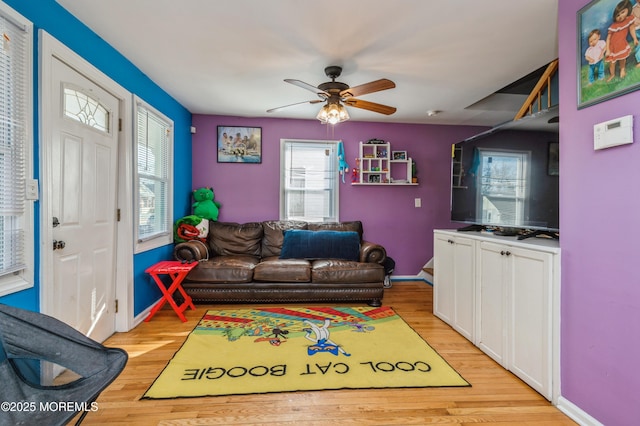 living room featuring ceiling fan and light hardwood / wood-style flooring